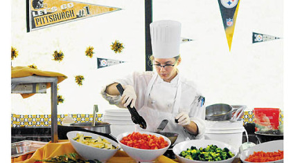 Ashley Moyer, 21, prepares to cook lunch for the Steelers at St. Vincent College.