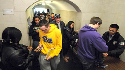 The line snakes out the door as security officers check photo IDs and examine bags in April at the Cathedral of Learning ground floor entrance along Bigelow Blvd. Increased security procedures took effect in the wake of multiple bomb threats on campus.