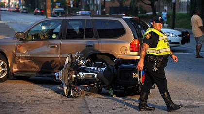 Police direct traffic around the scene of an accident involving an officer riding a motorcycle on Penn Avenue at its intersection with North Lexington.