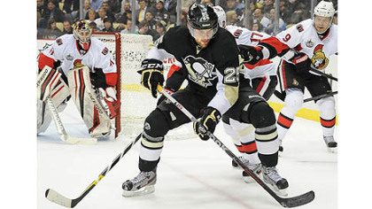 Penguins Eric Tangradi battles for loose puck against the Senators.