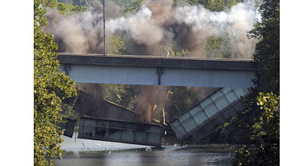 Structural steel from the 31st Street Bridge plunges into the back channel of the Allegheny River at Washington's Landing during a controlled explosion Thursday morning. The north end of the bridge will be rebuilt to incorporate a new interchange with Route 28.