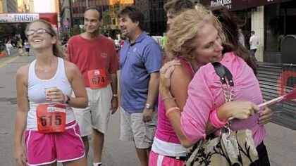 Christina Schuliger, 19, far left, who survived a brain tumor two years ago, enjoys the finish Friday of the GNC Live Well Liberty Mile with her mother, Janine Schuliger of Marshall, center, hugging her sister, Joanne Greer of Hampton.
