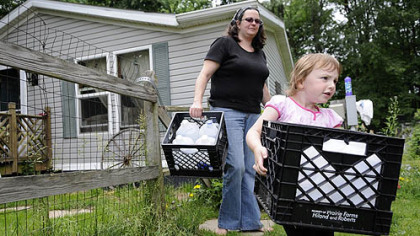 Kim McEvoy and her daughter, Skylar Sowatsky, 3, load empty jugs into the car so Ms. McEvoy can refill them with clean water at work.  The family has been without running water since January.  "This is America 2012. Look at what's happening. We have all this technology but no water," she said.
