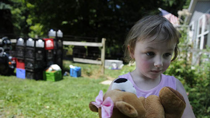 Skylar Sowatsky, 3, stands outside her home in the Woodlands on moving day. Skylar, her mother, Kim McEvoy, and father, Peter Sowatsky, moved out of the area after living without water since the winter of 2011. "Once you lose water, basic human needs are all that matter. I feel like I can relate to people on the other side of the world living without water," Ms. McEvoy said.