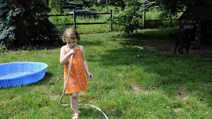 Skylar Sowatsky, 3, plays with a garden house outside of her home on May 29.  Skylar's mother, Kim McEvoy has moved them out of the Woodlands because they have no water at their home.