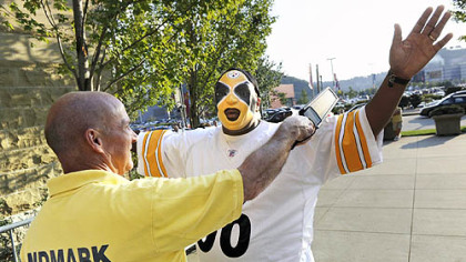 Jesse Randolph of Duquesne is checked with a metal detector Sunday evening by Landmark Security's James Turner as he enters the gates at Heinz Field for the Steelers' preseason game against the Indianapolis Colts.