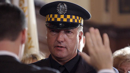 Cmdr. George Trosky salutes as slain officers are carried into the Petersen Events Center for services in 2009.
