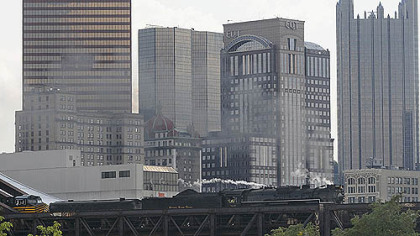 The 404-ton No. 765 steam locomotive of the Fort Wayne Railroad Historical Society leads its train carrying railroad enthusiasts Monday across the Fort Wayne Bridge over the Allegheny River from Downtown Pittsburgh. The David L. Lawrence Convention Center provides the backdrop.
