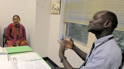 Benedict Kilang, right, a refugee employment specialist with the Jewish Family & Children's Services, sits with Tharka Timsina to help her find employment. Ms. Timsina is a refugee originally from Bhutan who came to the United States through Nepal.