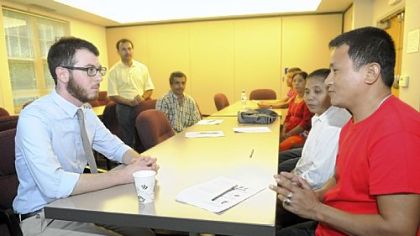Brendan Coticchia, left, a refugee employment specialist with Jewish Family & Children's Services, runs a workshop for refugees trying to enter the workforce. He sits with refugee Purna Tamang as part of a mock interview.
