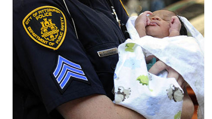 Three-day-old Bryce Coleman is carried to an ambulance by a Pittsburgh police officer Thursday evening.