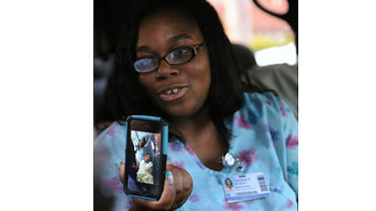 Taliesha Woodson, sister of  Rhonda King, mother of Bryce, the kidnapped baby from Magee Hospital, talks to reporters and holds a photo of the boy after he was safe back at the hospital.