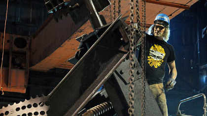Corey Lyons of Polish Hill works to ready of one of the two tall steel sculptures, titled "The Workers" at the LTV  Hazelwood Plant, so it can be placed on a trailer for the trip to their new home on the South Side.  Mr. Lyons is one of the 21 artists who worked on the project.