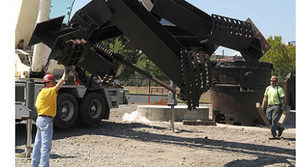 One of the two sculptures, titled "The Workers," was  lowered after  arriving at Riverfront Park on the South Side.