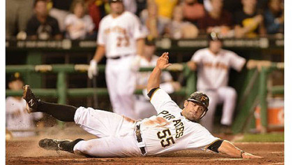 Catcher Michael McKenry slides safely in to home plate to score one of the Pirates' four runs against the Brewers in the fifth inning Saturday at PNC Park.