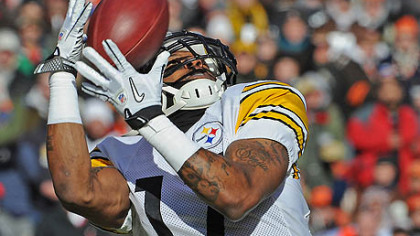 The Steelers' Mike Wallace, hauling in pass from Ben Roethlisberger for a touchdown in 2011, is back in camp.