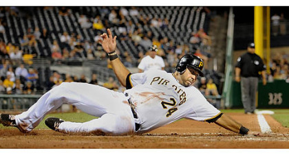The Pirates' Pedro Alvarez reaches out to touch home as he slides safely past Cardinals catcher Tony Cruz.