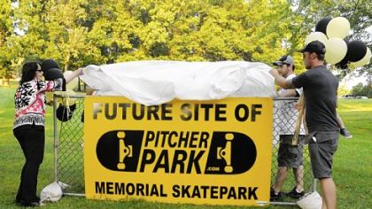 Mary Pitcher and her sons, Jonathan, right, and Brady, unveil a sign in Carnegie Park, the future site of Pitcher Park, a skate park named in honor of the two sons she lost in a drowning accident in 2008.