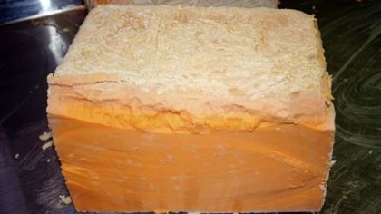 This photo shows a 28-year-old block of cheddar, one of three boxes of unintentionally aged cheddar recently discovered in a Milwaukee cheese market.