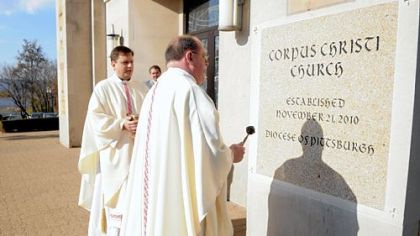 In this November 2010 photo, the Rev. Frederick L. Cain, regional vicar, right, and the Rev. Stephen Kresak use a holy water sprinkler to bless the cornerstone of Corpus Christi Church in McKeesport.