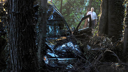 A police car hangs over the side of a bridge and into a wooded area off Ohio River Boulevard after it crashed early Tuesday morning during a chase of a suspect.
