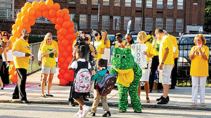 Students are greeted by teachers, administrators, volunteers and Ready Freddy the frog upon their arrival for the first day of kindergarten at Weil Elementary in the Hill District. The first-day pep rally -- a tradition in its fourth year at Weil -- is a way to get kindergartners, who are "typically scared to death," excited about starting school, said Holly Ballard, the school's principal.