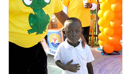 Four-year-old Pithas Pierre is greeted for his first day of kindergarten at Weil Elementary in the Hill District today.