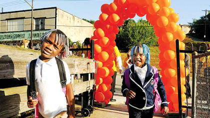 Jordan Jamison and Journey Darby, both 5, smile for the camera as they walk up to the doors of Weil Elementary today.