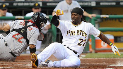 Andrew McCutchen slides safely past Astros catcher Carlos Corporan in the first inning Wednesday night at PNC Park.
