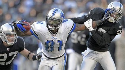 Calvin Johnson and Megatron: One and the same? Has anyone ever seen them in the same place? Here the Detroit Lions wide receiver stiff-arms Oakland Raiders cornerback DeMarcus Van Dyke (23) as defensive back Matt Giordano (27) approaches during a game last year in Oakland.