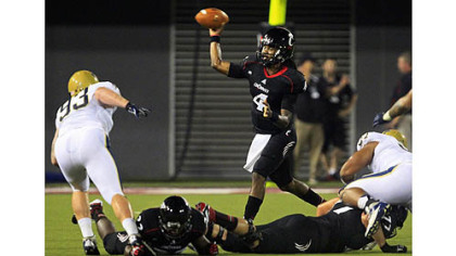 Cincinnati quarterback Munchie Legaux (4) passes against Pittsburgh in the first half.