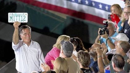 Republican candidate Mitt Romney holds up a license plate given to him by a supporter in Nashua, N.H.