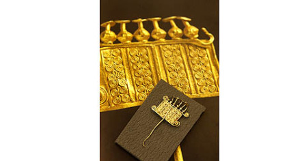 A broach from the Penn collection is shown against a broach in a book known to be from Troy that is now in a collection in Russia.