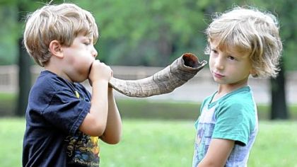 Eli Firman, 6, of Sq. Hill, blows a shofar in his 4 year-old brother Brian's ear during the  Apples and Honey Festival in Schenley Park.