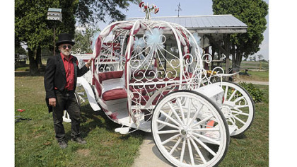 Bill Wolfe of Apollo stands in front of a carriage used mostly for weddings at his horse-drawn carriage business, which supplies carriages for a variety of occasions.