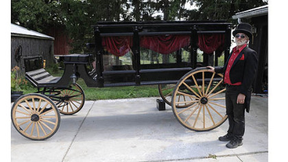 Bill Wolfe stands in front of a carriage used primarily for funerals at his horse-drawn carriage business, which supplies carriages for everything from funerals to weddings. There are more than 20 different carriages and more than 20 horses at his farm in Apollo.