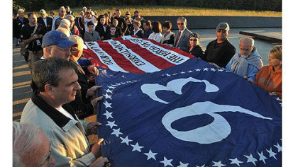 Volunteers at the Flight 93 National Memorial site in Somerset County unfurl a memorial flag that was created in 2011 by Gene Stilp.