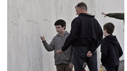 Air Force Major Robert Firman, who is stationed at the Pentagon, talks with his sons Aidan, 11, right and Evan, 8, about the events of September 11, 2001 as they attend events at the national memorial in Stonycreek Township.