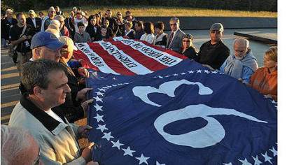 Volunteers at the Flight 93 National Memorial site in Somerset County unfurl a memorial flag that was created in 2011 by Gene Stilp.