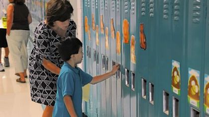 Gateway kindergarten teacher Jill Mutschler helps 5-year-old Jesus Ramos with his locker during Cleveland Steward Elementary's two-day kindergarten orientation in August. Full-day kindergarten is now available districtwide.