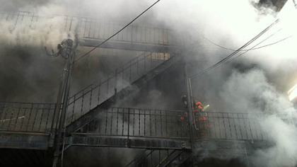 Firefighters struggle though heavy smoke while battling an early morning blaze along Merchant Street in Ambridge.