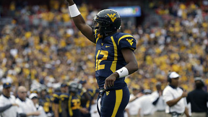 West Virginia quarterback Geno Smith reacts after a touchdown during the first half of an NCAA college football game against James Madison.
