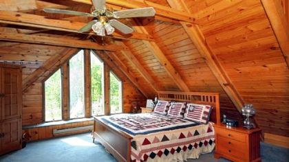 The 20-by-18-foot master bedroom has a bank of floor-to-ceiling windows accentuating the roof peak.