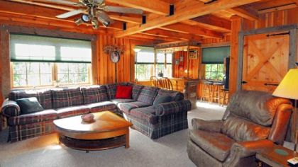 The family room, which features solid wood beams and a custom bar in the back has carved columns with the same finish as the walls.