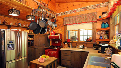 The 21-by-13-foot kitchen has mostly open wood shelving at various heights, leaving space for canisters and decorative items.