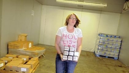 Sam Kniha, programs administrator for the Corner Cupboard Foodbank in Waynesburg, carries food from the dwindling supplies in the cooler.