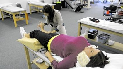 Ms. Gibson has her ankle worked on by therapist Annie Ursom at the East Suburban Sports Medicine in Monroeville. Ms. Gibson?s ankle was shattered after she was hit by a drunken driver in August 2011.