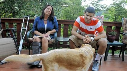 Nettie Gibson sits on her porch with her son, Dominic, 13, and their dog, Dude.