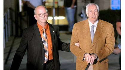 Jerry Sandusky is led in handcuffs by Centre County Sheriff Denny Nau after being found guilty June 23 on 45 counts of sexual abuse at the Centre County Courthouse in Bellefonte.