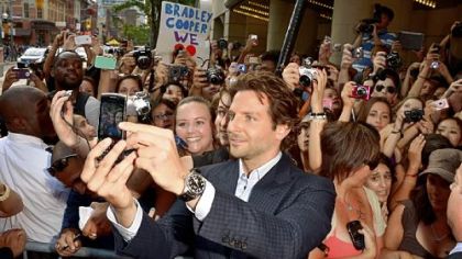 Bradley Cooper poses for a photo with fans at the Toronto International Film Festival. The actor had two films screening there.